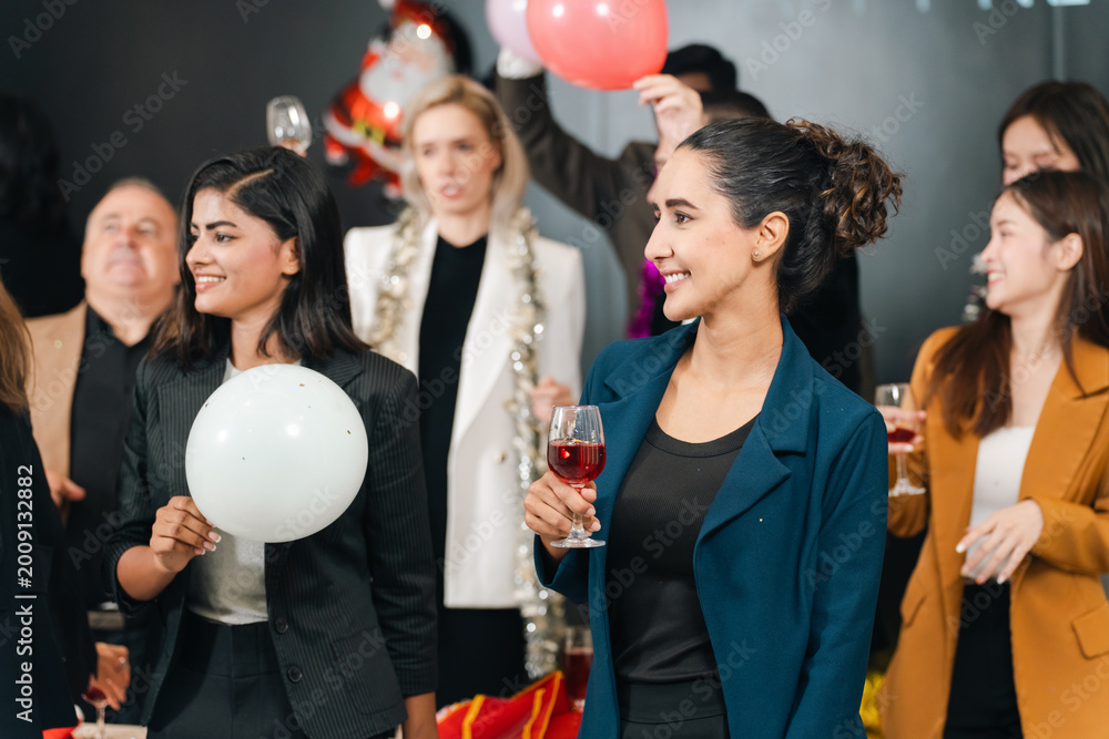 Obraz premium Party celebration group of adult people holding balloon and glass in indoor event, smiling social gathering with festive mood