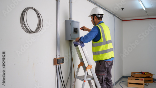 Fotografie Electrician servicing small wall unit indoors