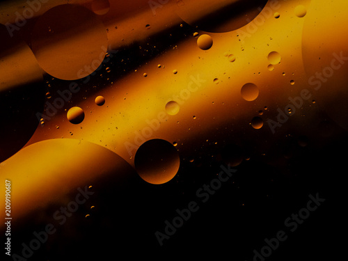 Luxury golden oil bubbles macro background, premium cosmetic liquid texture, elegant black and gold abstract fluid