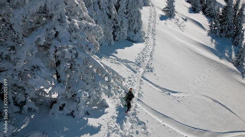 hombre caminando en la nieve con tabla de snowboard