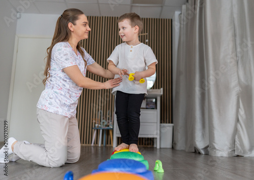 Child Balance Therapy Session With Pediatric Therapist Guiding Motor Skills On Colorful Stepping Stones