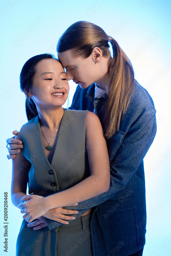 Naklejka premium Young couple shares a tender moment filled with love and warmth under soft blue light