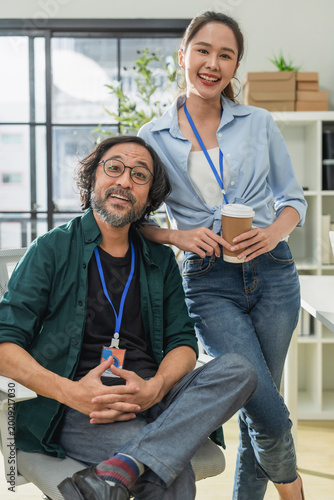 Portrait of professional Asian business team in modern office, happy coworkers smiling and posing at creative workspace