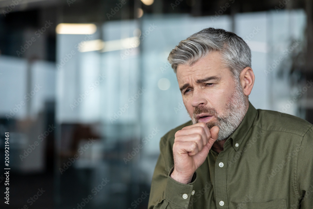 Naklejka premium Mature man coughing feeling unwell with flu symptoms