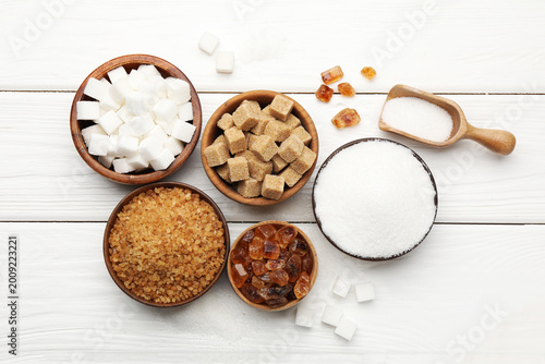 Photography Different types of sugar on white wooden table, flat lay