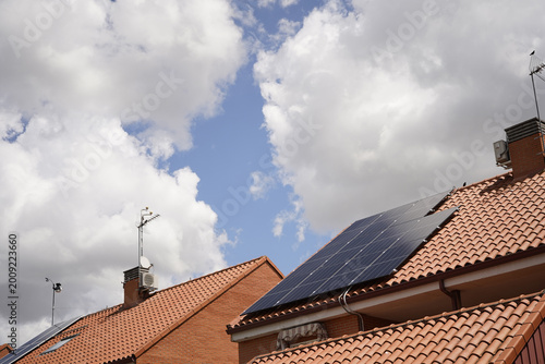 Cielo y Tejados de casas con tejas y placas solares, energía, autoconsumo energético
