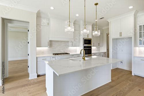 Modern white kitchen with island and pendant lighting in new construction home