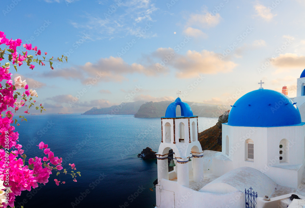 Fototapeta premium traditional greek village Oia of Santorini, with blue domes of churches in sunset light, Greece