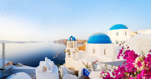Photos traditional greek village Oia of Santorini, with blue domes against sea and cald