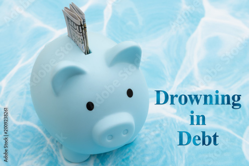 Fotografia Piggy bank drowning in debt financial crisis