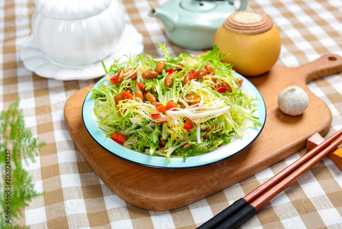 Fotografie Fresh lettuce salad with beans and shredded vegetables on wooden board