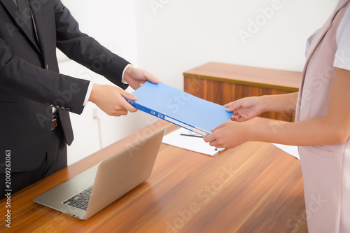 Fotografie Business colleagues handing over document folder in office