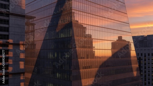 Modern Glass Office Building Reflection During Sunset in Urban City Skyline