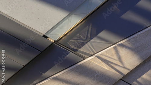 Modern glass building facade with reflective surfaces and geometric design elements