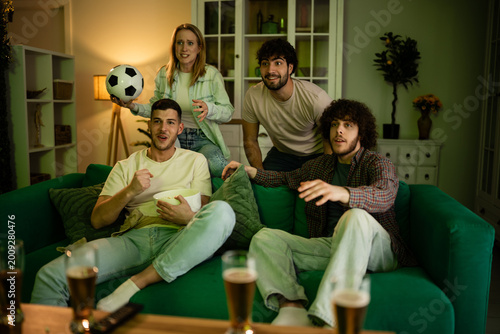 Fotografía Friends watching soccer game on television at home