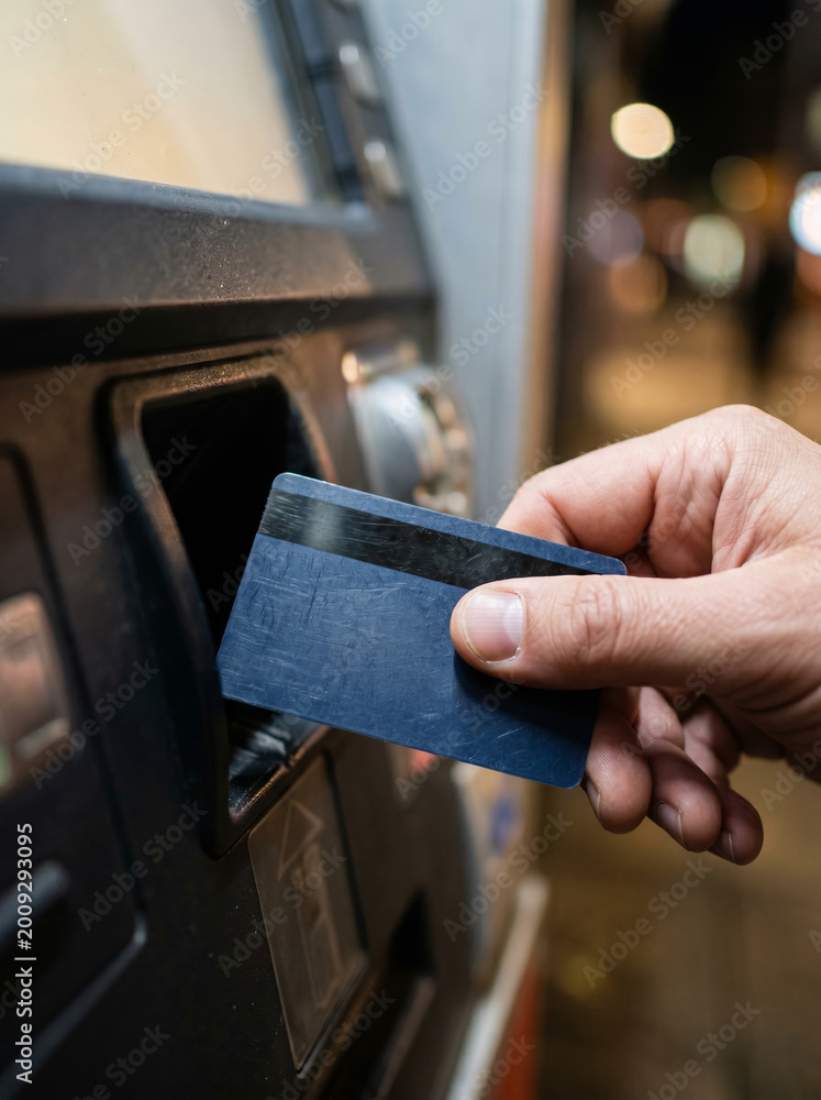 Obraz premium Inserting a credit card into an outdoor ATM machine