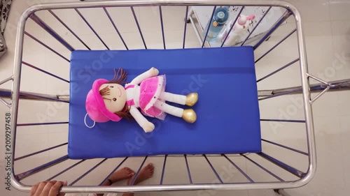 Doll lying on a blue hospital bed in a medical room during the day