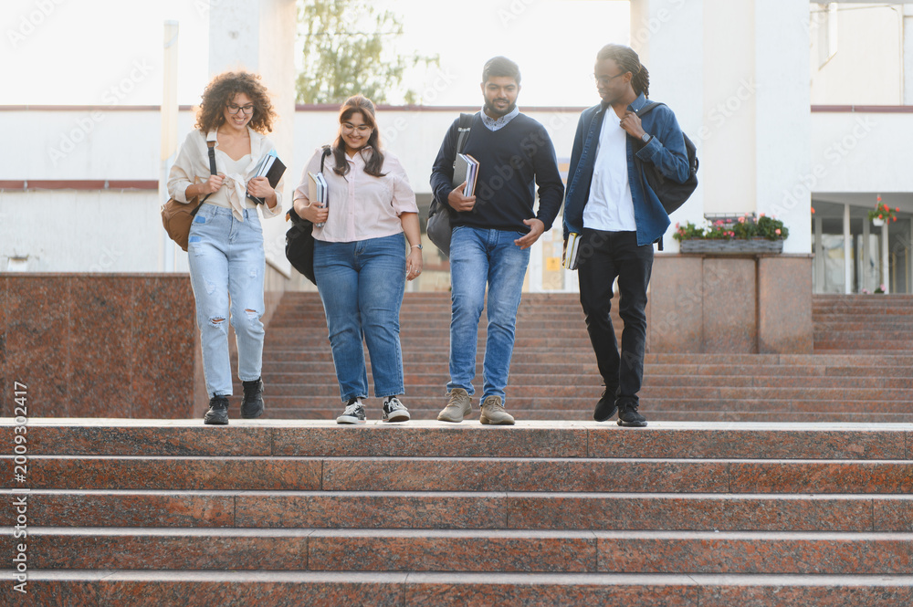 Obraz premium Diverse students walking downstairs on university campus
