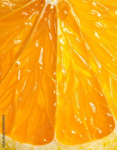 Close up macro shot of a vibrant orange citrus fruit slice with glistening pulp and segments natural juicy texture and bright lighting