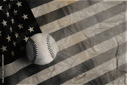 Old vintage baseball sport americana concept for holiday background with ball on old texture of American flag for Fourth of July holiday concept with copy space.