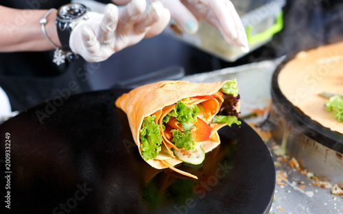 Photos Making vegetable crepe, roll with tomatoes and lettuce
