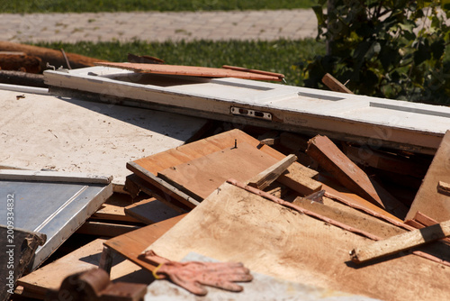 Close-up of pile of old wooden planks, discarded furniture parts, and construction debris outdoors