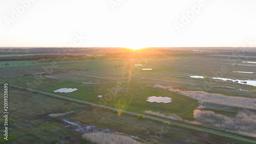 Aerial view of the LOFAR superterp radio telescope antennas situated in green fields under a golden sunset Buinen, Drenthe, Netherlands.
