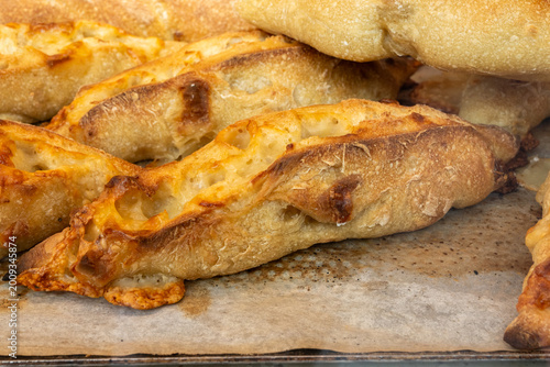 Handcrafted sourdough baguettes made in artisanal bakery in Marais, Paris with long fermentation with cheese, olives and aromatic herbs, and crisp crust