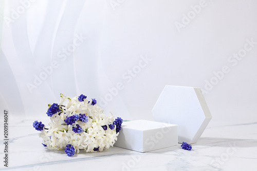 Empty product podium and fresh live spring flowers.Abstract beautiful flower arrangement with hyacinths and muscari,banner.Stage for business concept.Minimal modern aesthetics ,elegant beauty concept,