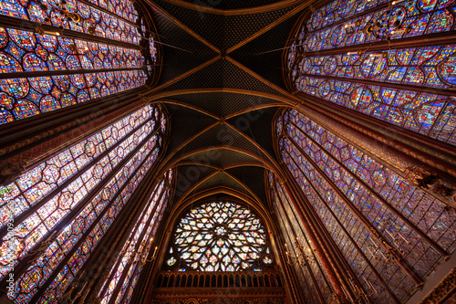 Obraz na płótnie Interior view of medieval Gothic cathedral featuring towering stained-glass windows that fill nave with colored light, detailed biblical iconography