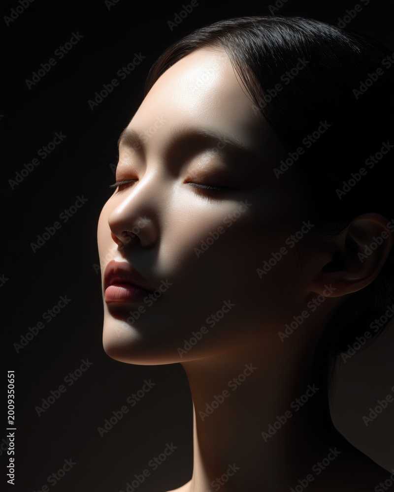 Fototapeta premium 目を閉じて静かに佇む女性の横顔。美容やリラクゼーションのイメージに最適なポートレート。