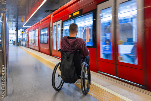 Person with disability on wheelchair is at a metro station.