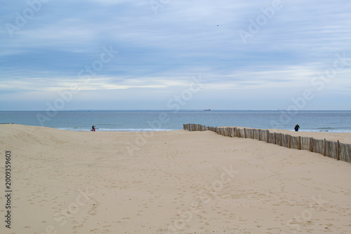 Calais beach in northern France, promenade near the sea, coastline, sand, dunes, France, La Manche, people walking far away, a large beach