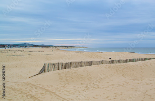 Calais beach in northern France, promenade near the sea, coastline, sand, dunes, France, La Manche, people walking far away, a large beach
