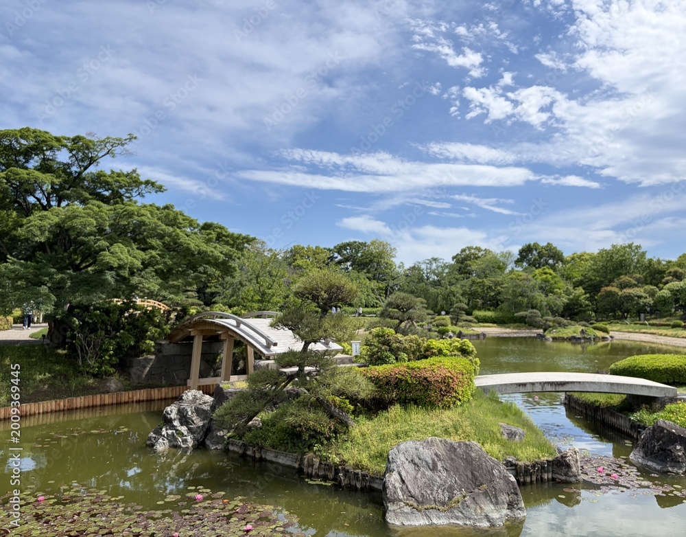 Fototapeta premium 池に浮かぶ中島と石組みのある日本庭園