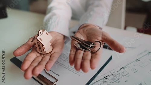 Moment of receiving house keys from female agent over signed papers. Symbol of new apartment ownership, moving day, successful purchase and comfortable future home lifestyle ahead.