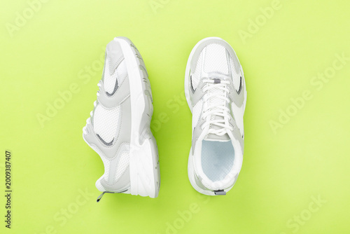 Foto Pair of sneakers on color background, top view