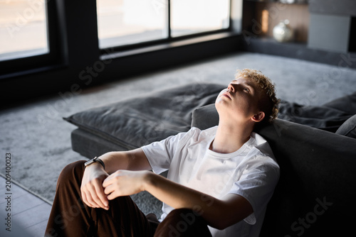 Fotografie Teenager with blond hair lying peacefully close to sunlight