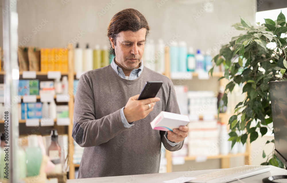 Ταπετσαρία Adult man buyer scanning qr code for box of pills in pharmacy