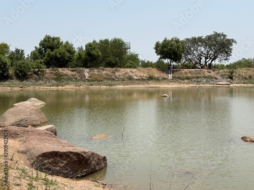  Lake with foreground rocks and distant trees