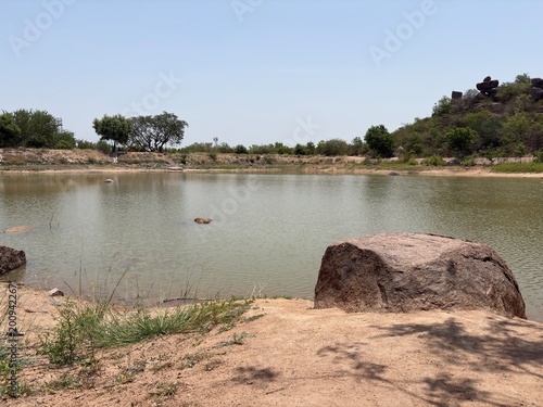 Calm rural lake with rocks and trees