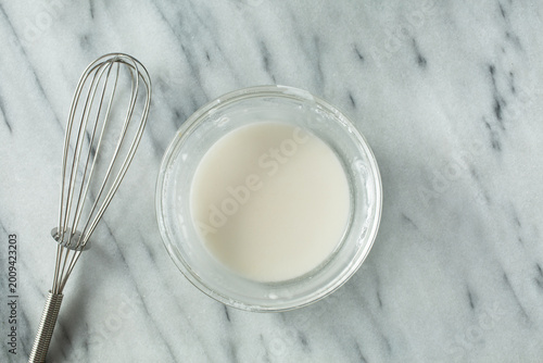 Cuadro en lienzo A top down view of a glass bowl of corn starch slurry.