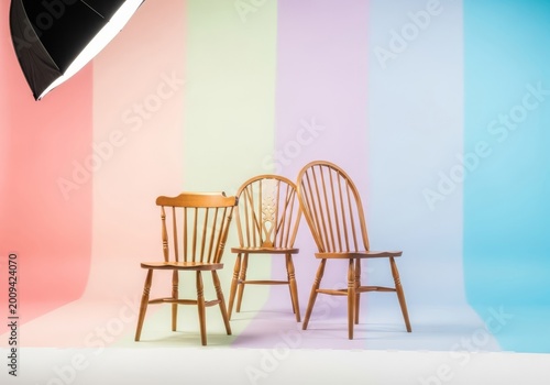 An elegant arrangement of antique wooden chairs positioned for a formal portrait featuring soft pastel backdrops and silky smooth gradients, muted, dreamy, tranquil