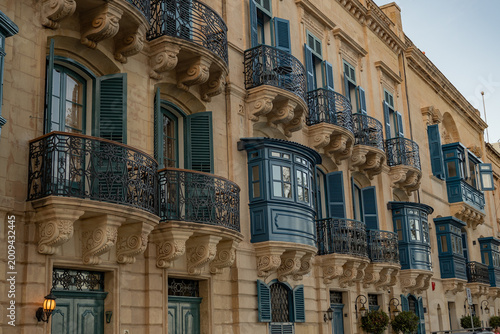 Horizontal view of iconic blue balconies and limestone facades in Valletta. Traditional Mediterranean street architecture, Malta.