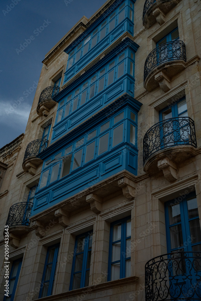 Obraz premium Epic traditional European town historic stone facade vertical panorama blue balconies. 
