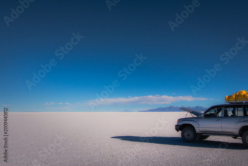 Photos Vast landscape of Salar de Uyuni salt flats with mountain reflections under a moody sky, Bolivia