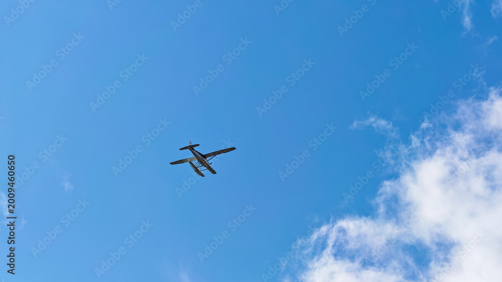 Fototapeta premium Sitka, Alaska - USA - August 3, 2024 - Seaplane Over Against a Blue Sky With Clouds