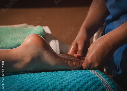Close-up of foot massage with essential oils in a warm setting.