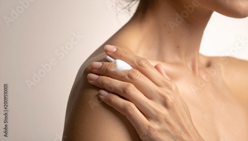 фотографія Woman's Hand Applying Moisturizing Cream to Shoulder for Skin Care