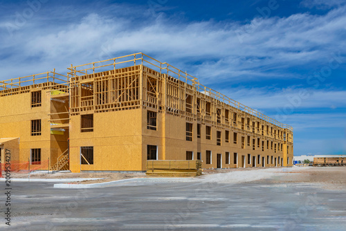 Quadro su tela Large multi-story wooden framing at a residential construction site under a blue